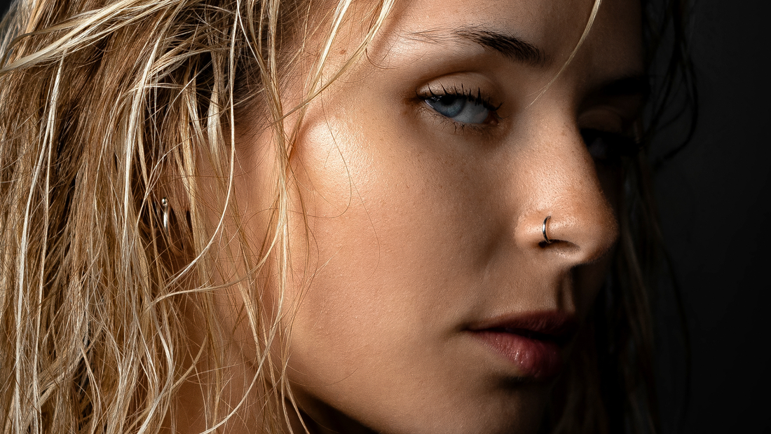 Donna con viso ovale e piercing alle orecchie