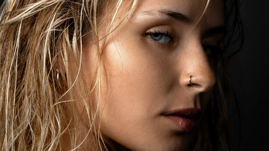 Donna con viso ovale e piercing alle orecchie